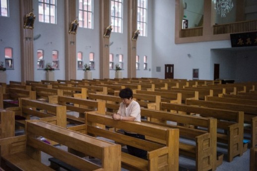 Une femme chinoise prie dans l'église flambant neuve de Tianjin